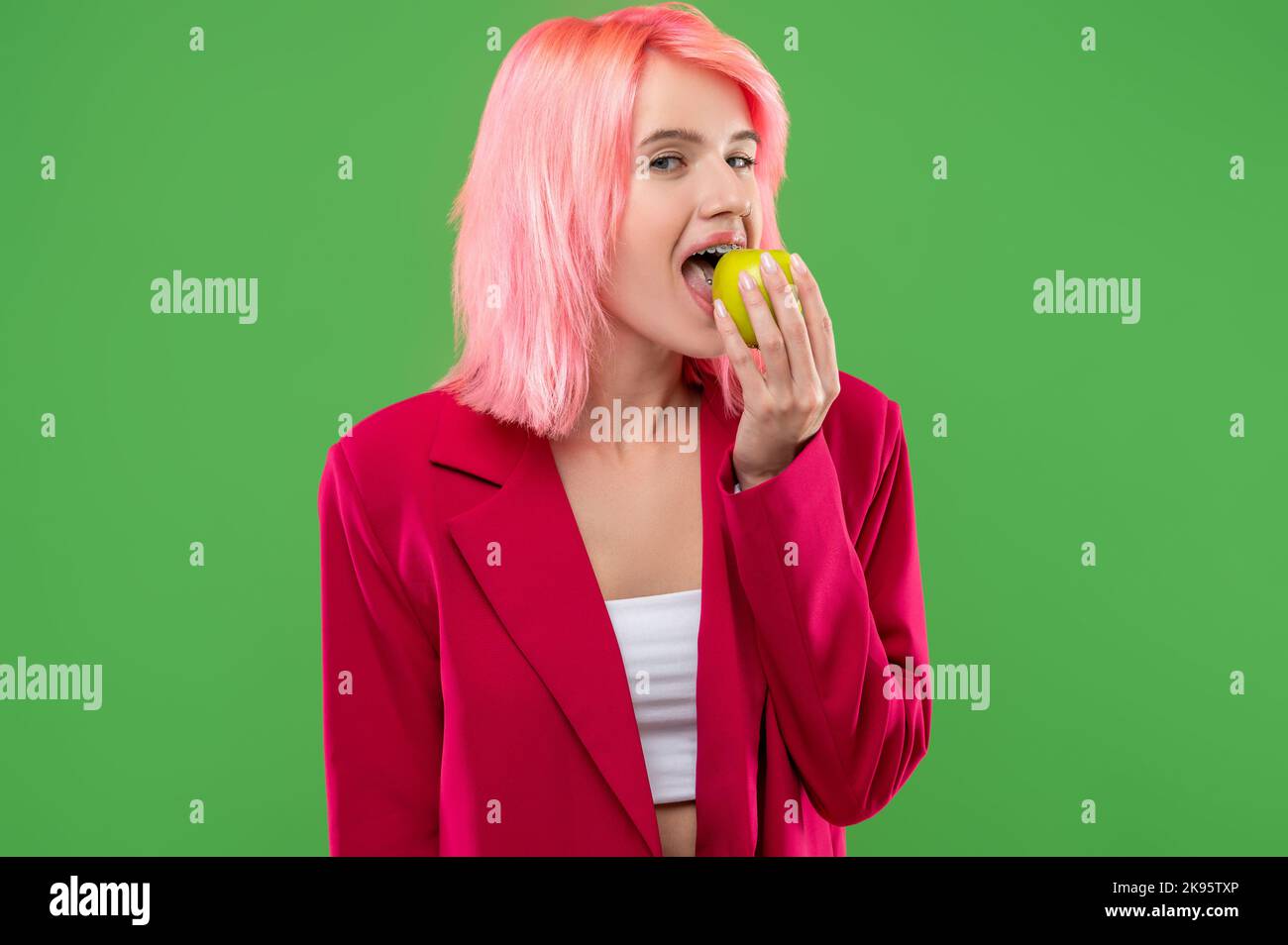 Extravagant young female eating healthy fresh fruit Stock Photo