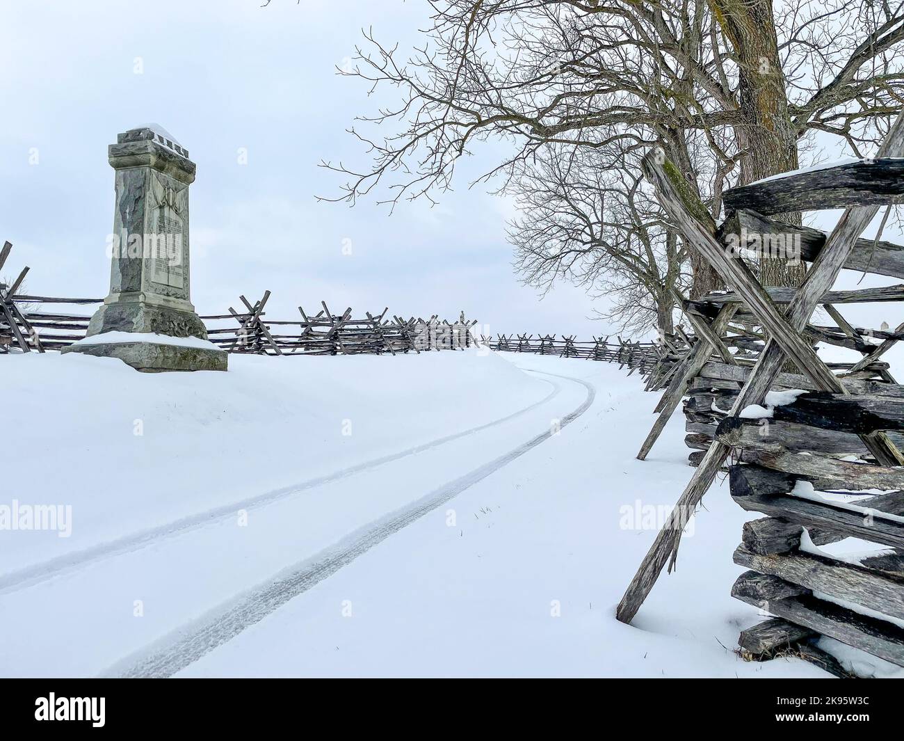 A Headstone on snowy land with metal barriers at the Antietam National Cemetery in Maryland, USA Stock Photo