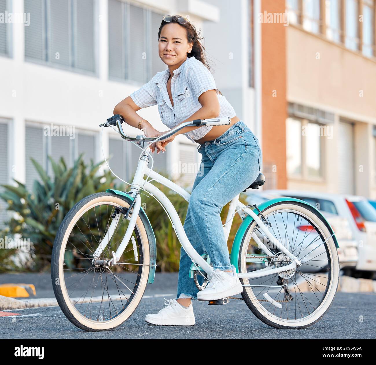 Bike, young woman and city portrait of student, gen z girl and influencer cycling in summer street for eco friendly carbon footprint. Happy asian Stock Photo