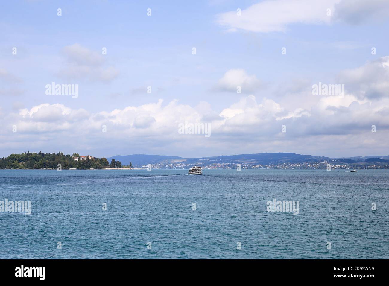A beautiful scene of sea water and green hills with houses on the ...