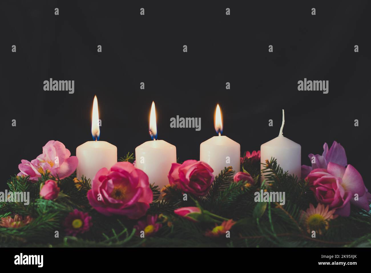 three burning advent candles on decorated rose flower pink advent wreath Stock Photo Alamy