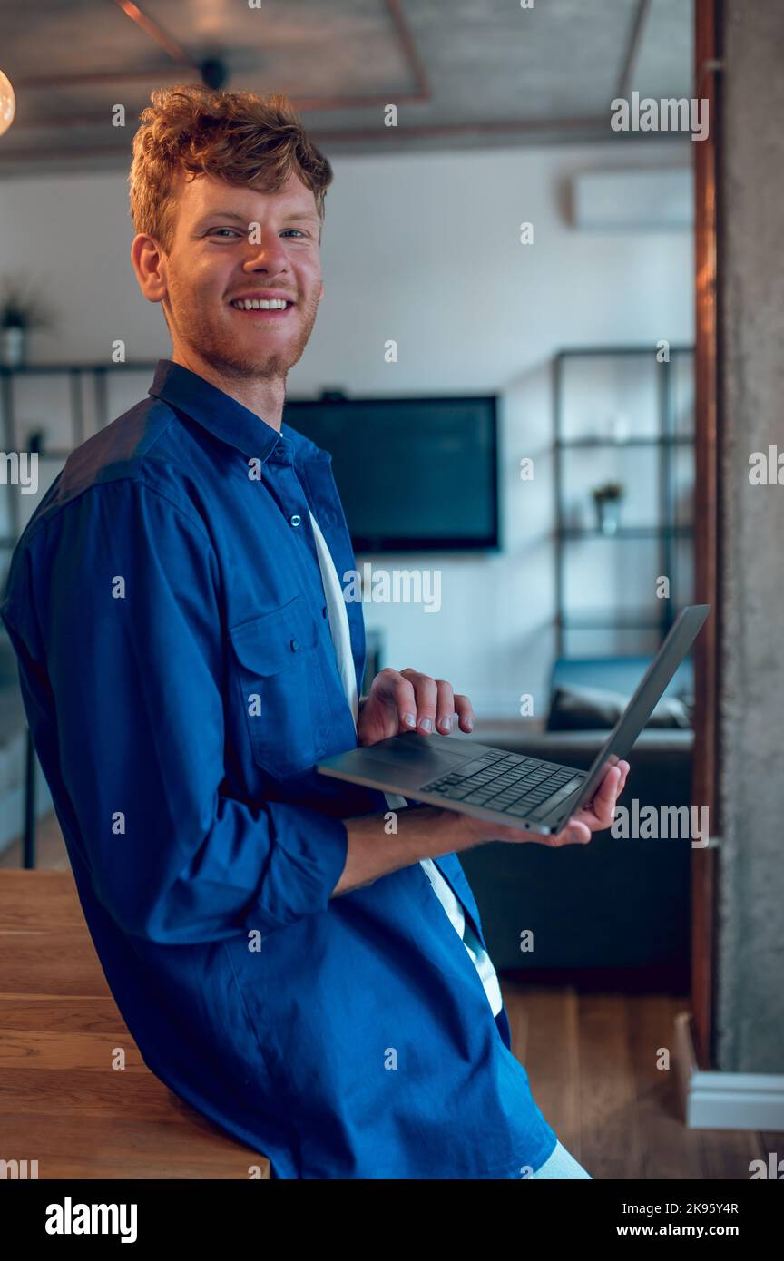 A ginger young freelancer working on a laptop Stock Photo