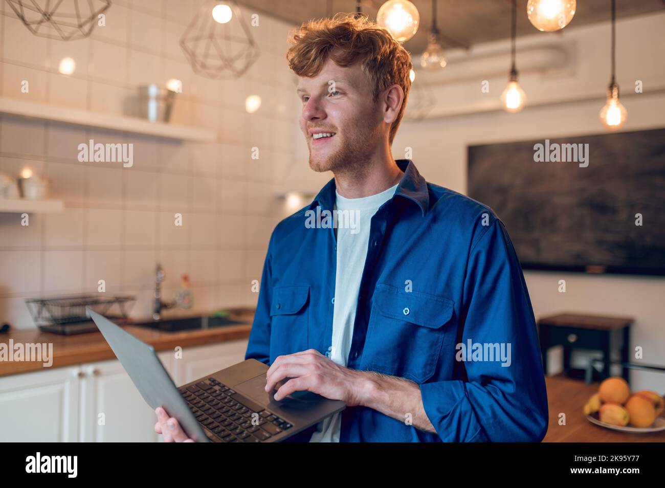 A ginger young freelancer working on a laptop Stock Photo