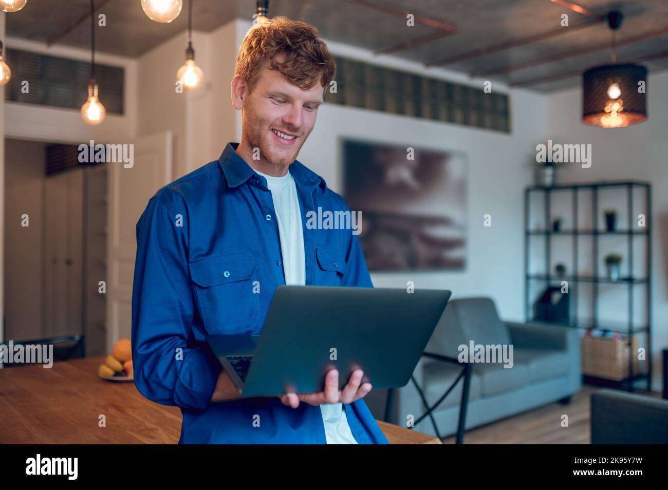 A ginger young freelancer working on a laptop Stock Photo