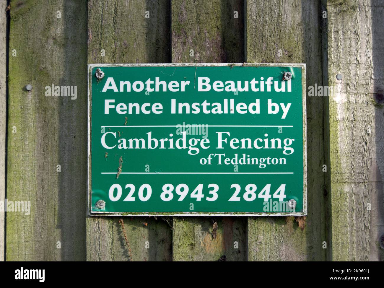on a wooden garden fence in kingston, surrey, england, the installers leave a sign claiming to have provided another beautiful fence Stock Photo