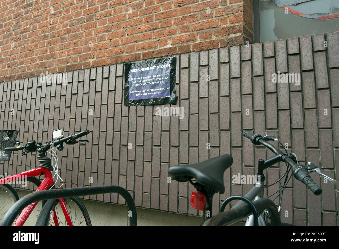 above a cycle parking rack, a sign warns cyclists that the area is not covered by cctv and cycle thefts are known here, in kingston, surrey, england Stock Photo