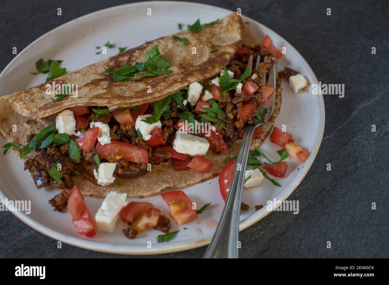 Savory pancake with ground beef, onion, tomatoes and feta cheese Stock Photo
