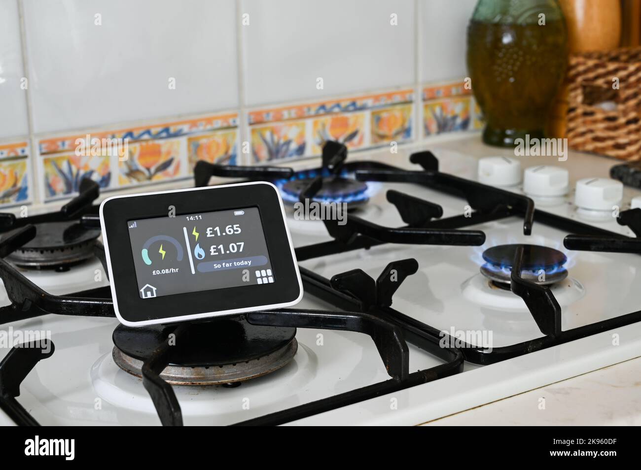 Smart meter on a gas hob with flames lit Stock Photo