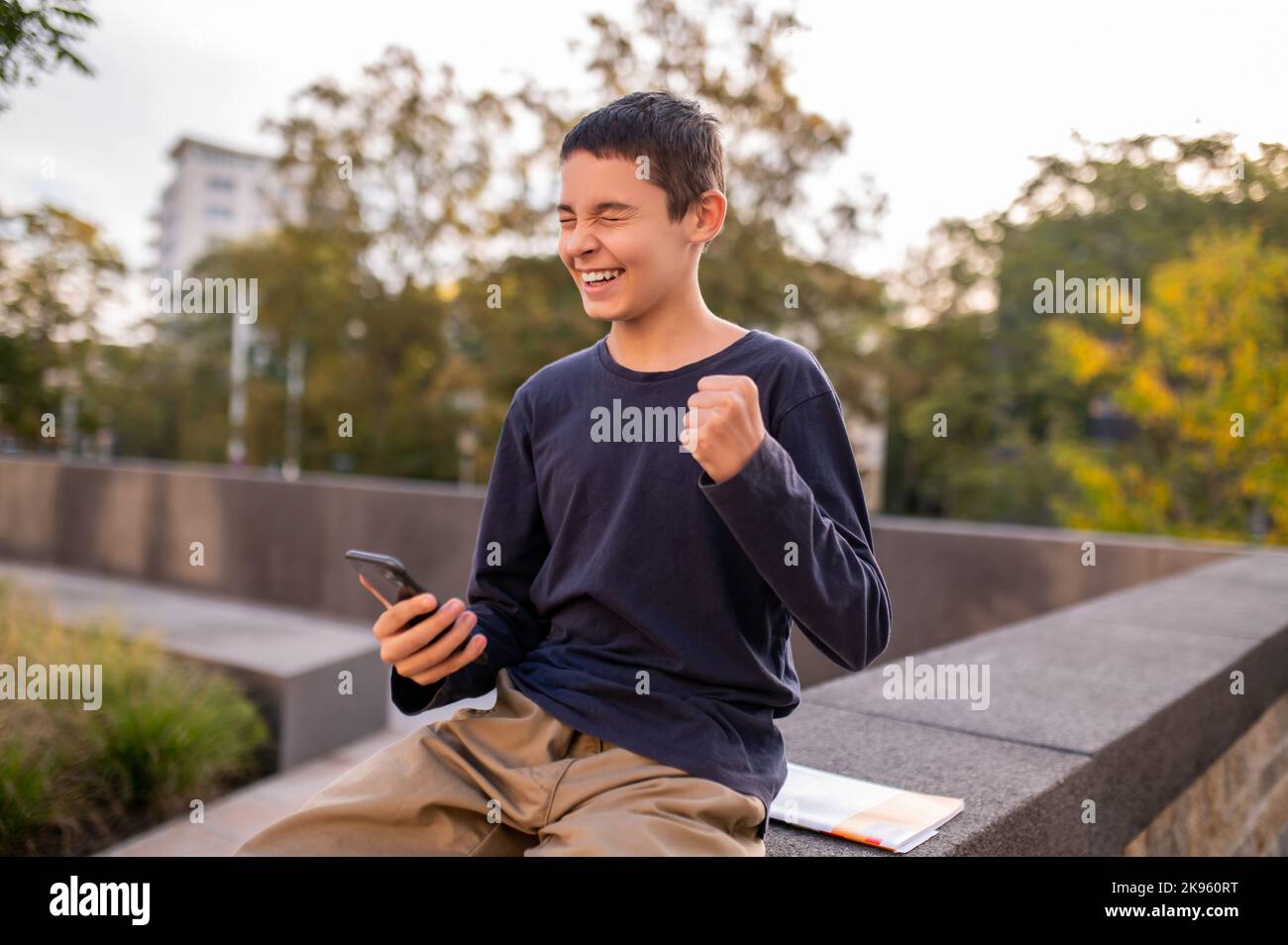 Teen with the smartphone rejoicing at good news Stock Photo