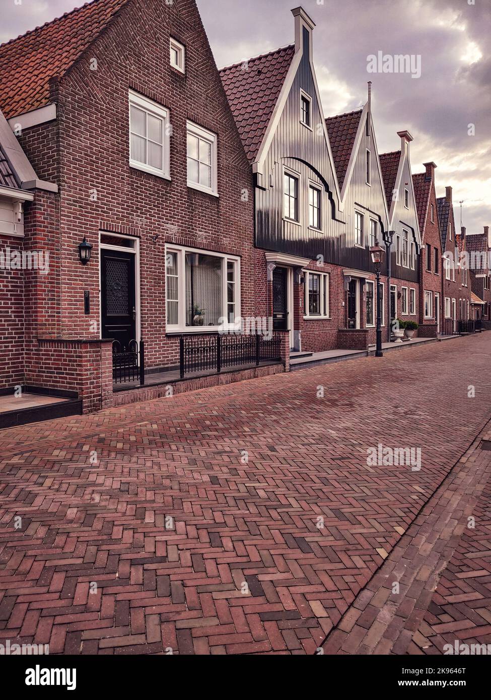 The vertical view of brick-built houses in a row under the cloudy sky ...
