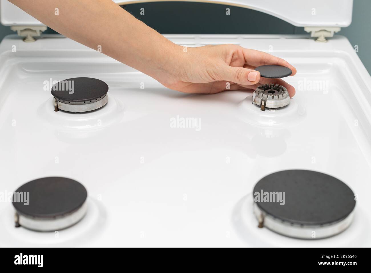 man washing a gas stove with a rag. hostess cleaning the kitchen. assembling gas burner Stock