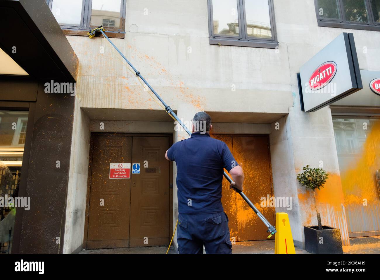 London, UK. 26 OCT 2022. A couple of Just Stop Oil activists spray-paint luxury car dealership in Mayfair. The climate protesters targeted H.R. Owen, Jack Barclay Bentley, and Ferrari Mayfair. Stock Photo