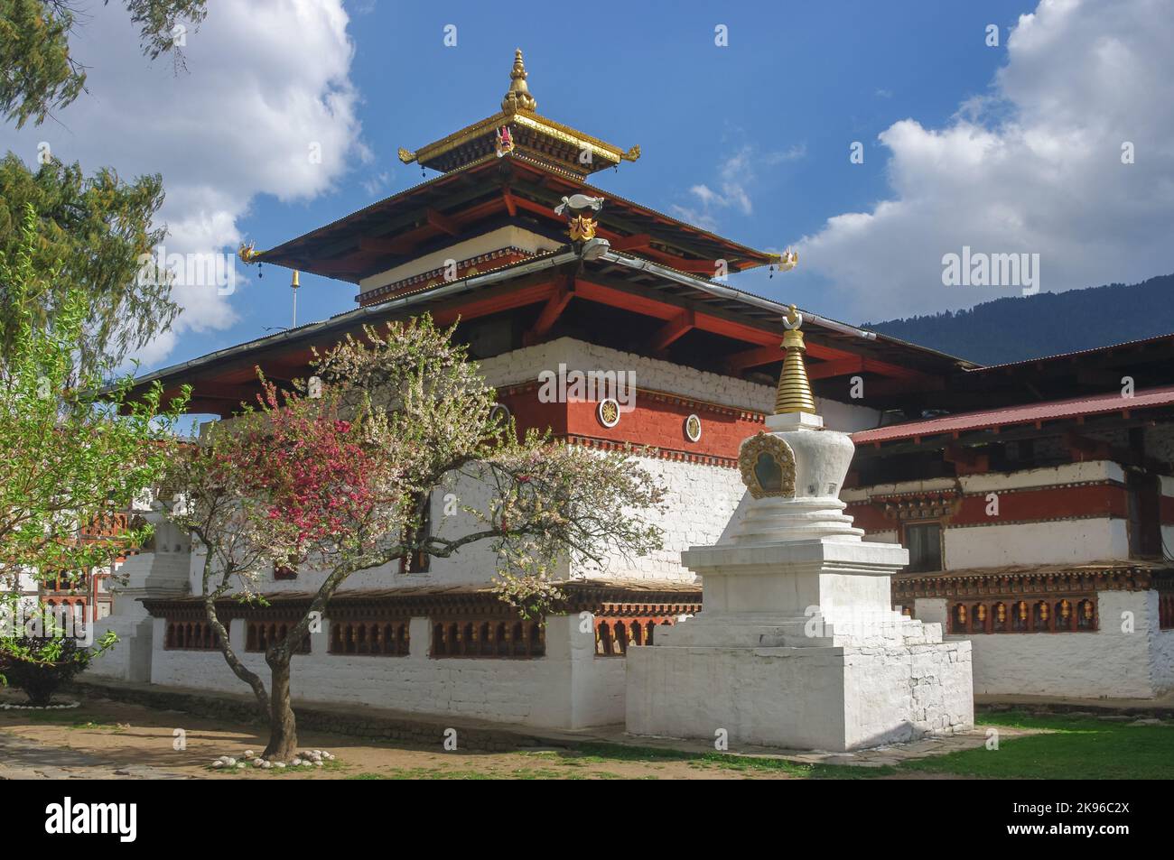 Scenic landscape view of ancient Kyichu lhakhang buddhist monastery in spring with blooming trees, Paro, Western Bhutan Stock Photo