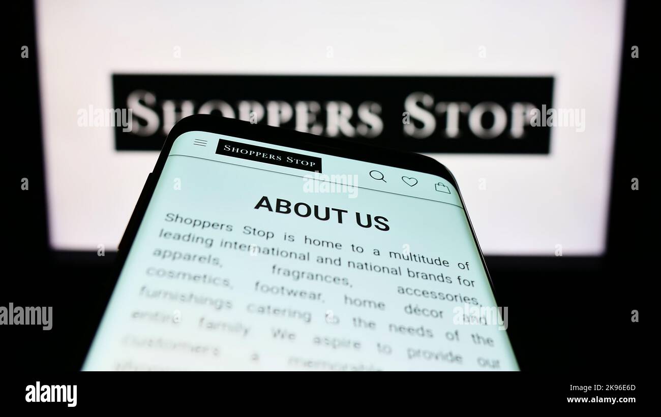 Mobile phone with webpage of Indian retail company Shoppers Stop Limited on screen in front of business logo. Focus on top-left of phone display. Stock Photo