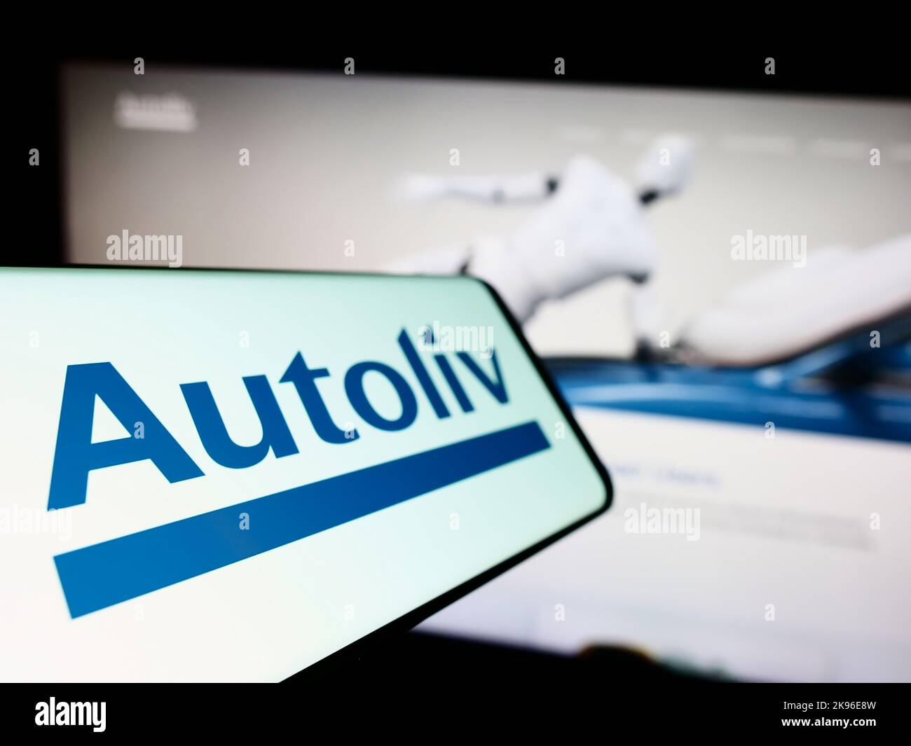 Smartphone with logo of automotive supply company Autoliv Inc. on screen in front of business website. Focus on left of phone display. Stock Photo