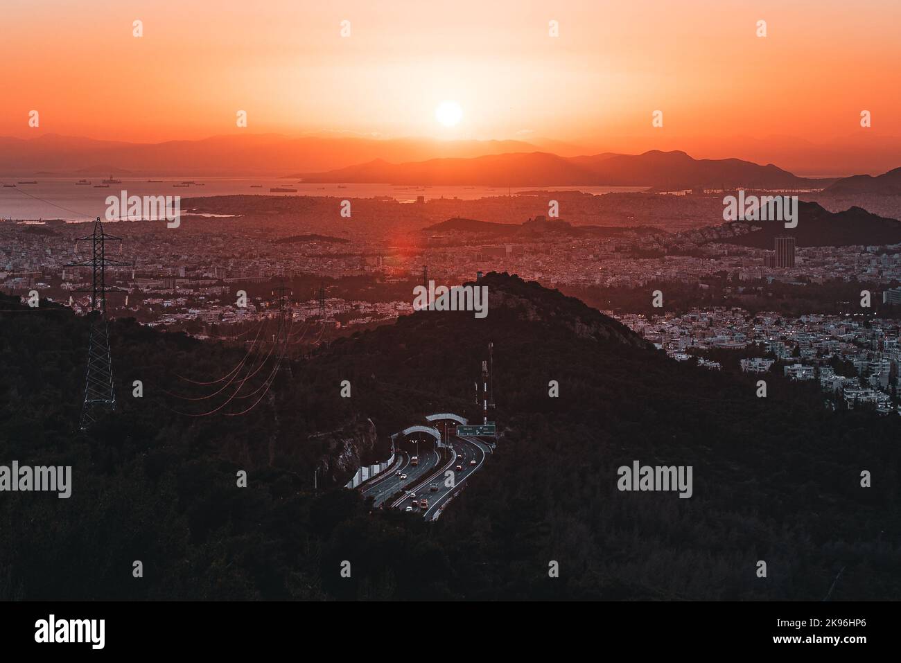 A big golden sunset over the city of Athens and the Attiki Odos road in Greece Stock Photo