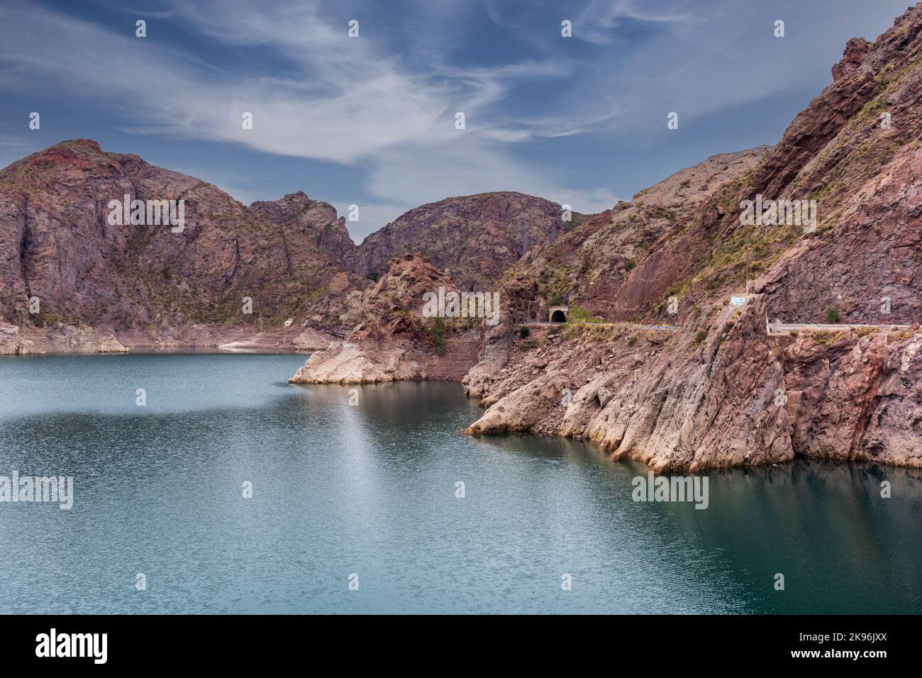 A cinematic lake surrounded by red cliffs in Provincia de Mendoza