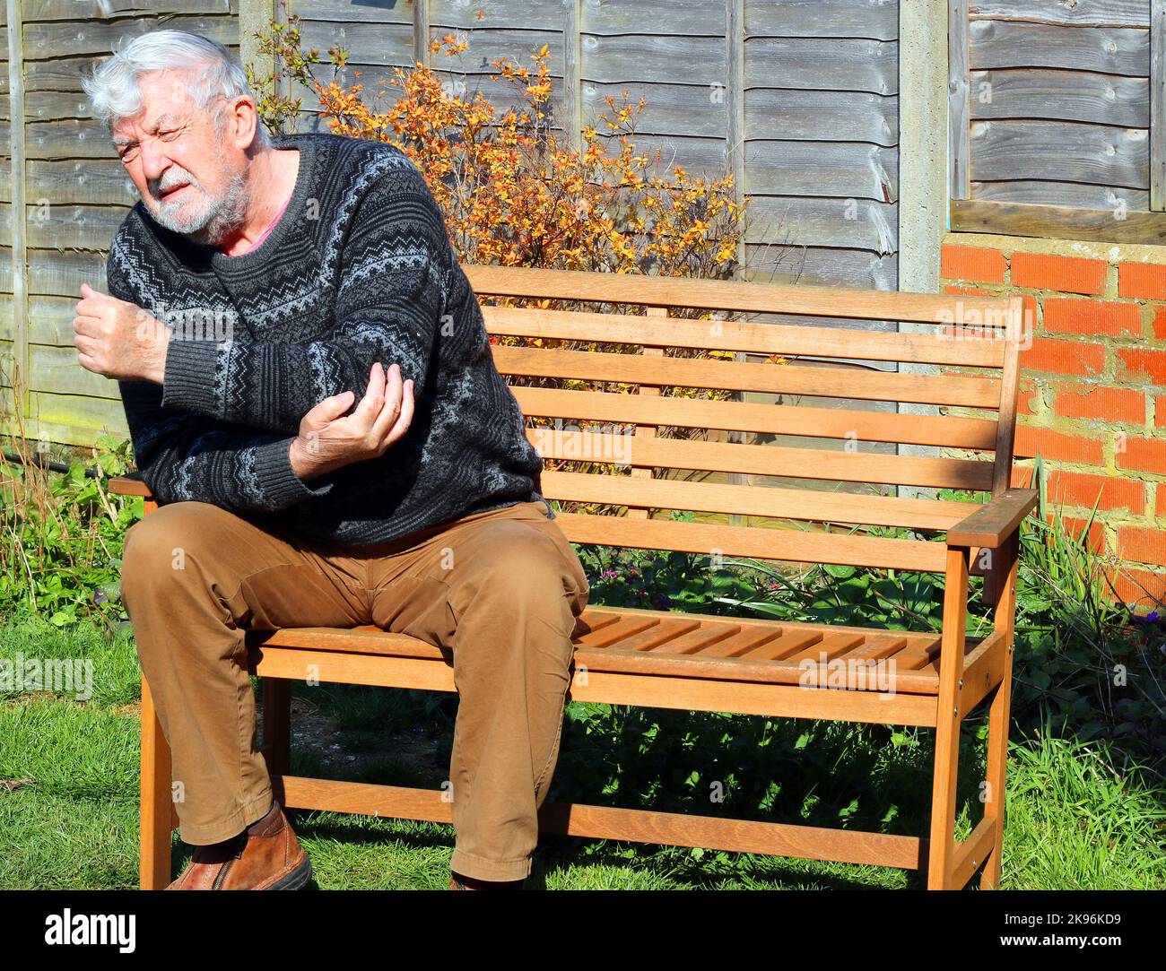 Senior or elderly man in pain, suffering from arthritis of the elbow and arm. Stock Photo