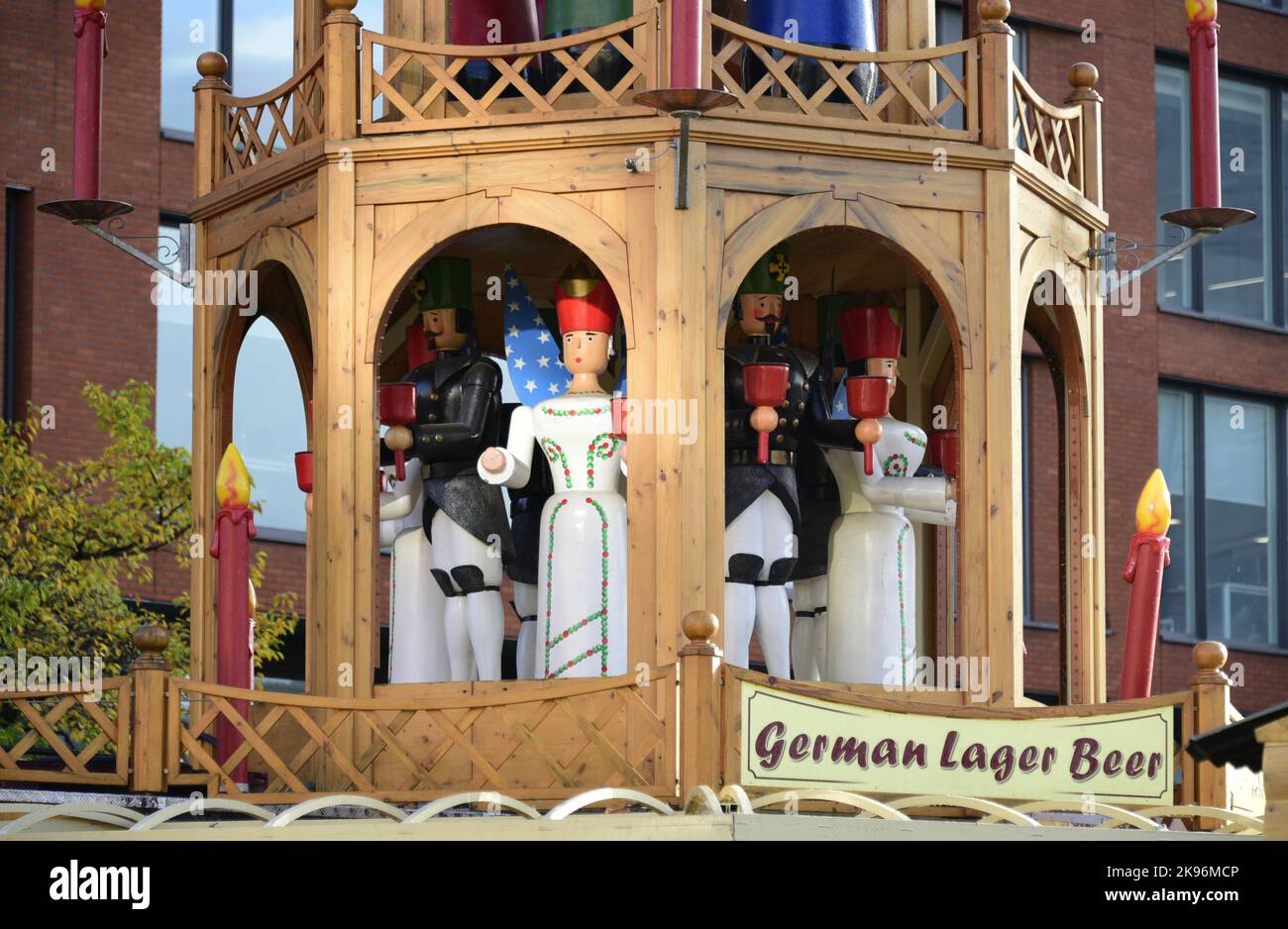 Wooden structure on top of a beer outlet as part of Manchester Christmas Market 2022, in Piccadilly Gardens, Manchester, England, UK, opening November 10, 2022. It advertises German lager beer. It features festive figures holding bells to ring in celebration of the Xmas season. Stock Photo