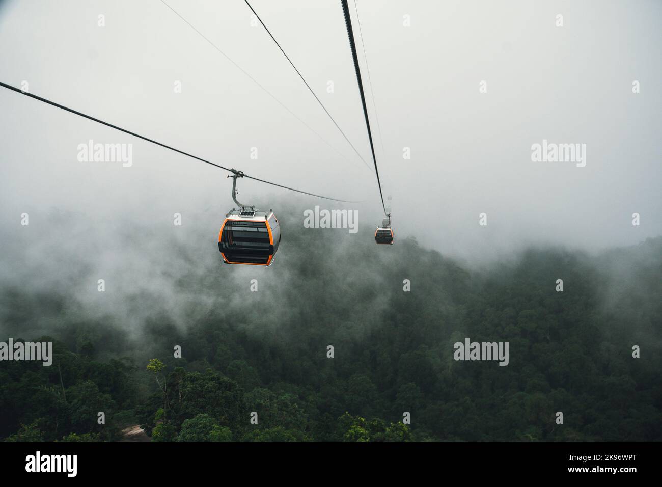 Cable car climbing up to foggy hill over thick forest in Banahill, Danang, Vietnam. Stock Photo
