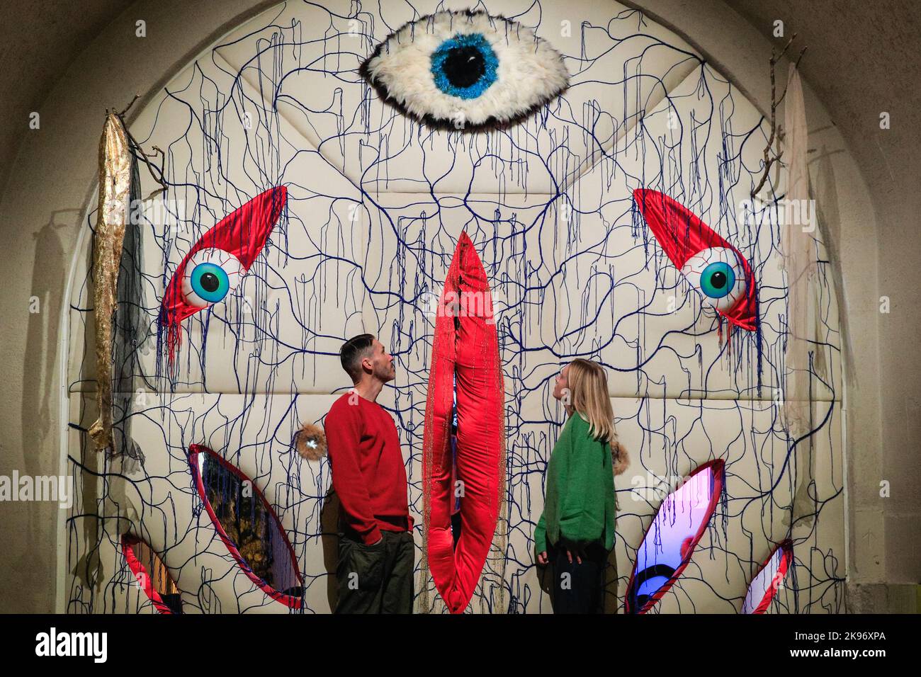 London, UK. 26th Oct, 2022. Staff pose with 'The Vesica', 2022, by Brett Gilbert. Ahead of Halloween, 'The Horror Show!' at Somerset House shows examples of horror's impact on the last 50 years of creative rebellion in Britain. New works by Noel Fielding, Gareth Pugh and Pam Hogg; iconic Spitting Image and David Bowie objects; large scale sculpture, painting and cabinets of curiosities are all shown. It runs until 19 February 2023. Credit: Imageplotter/Alamy Live News Stock Photo