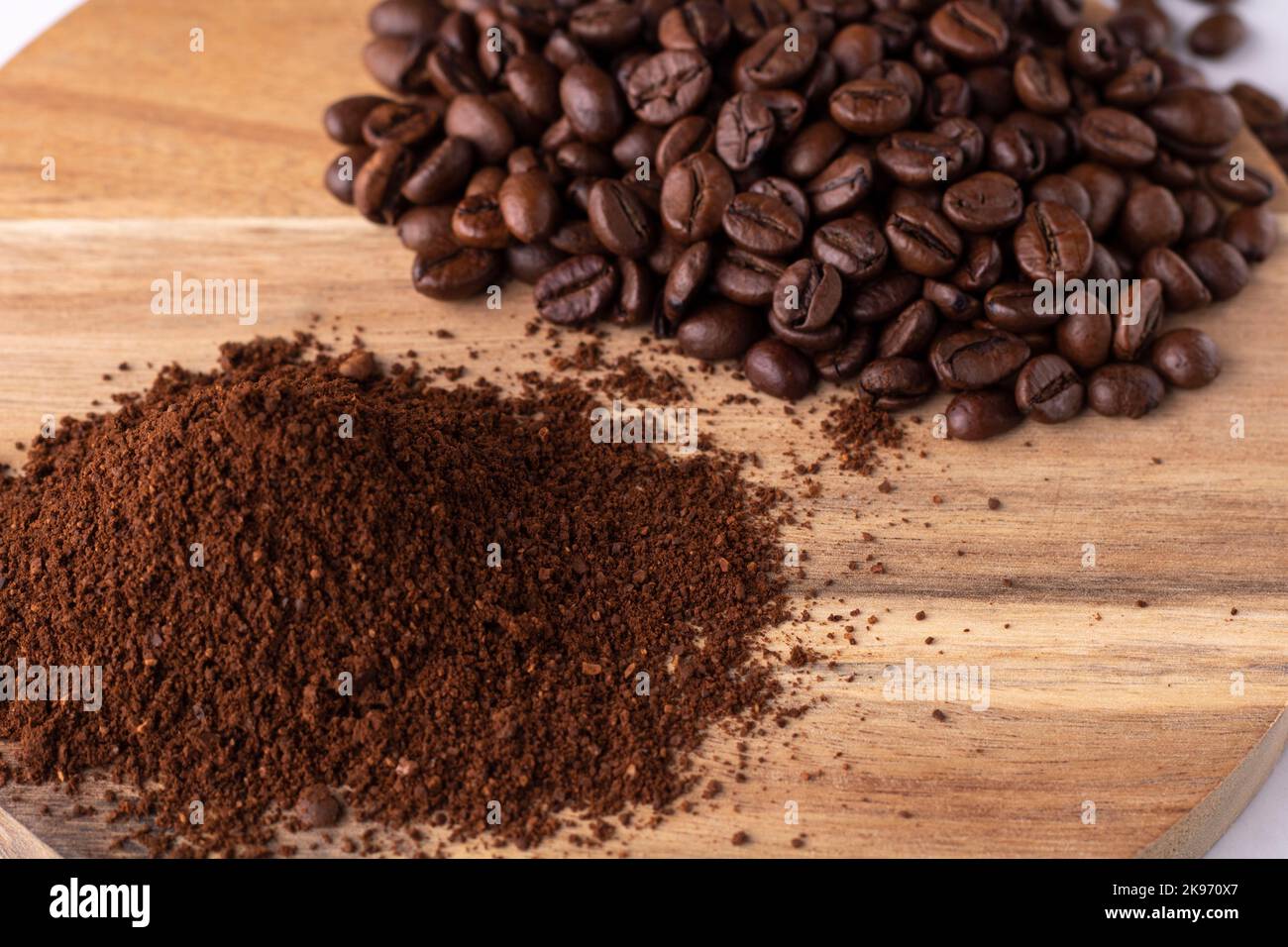 photo whole coffee beans and ground coffee lying on a wooden board top view Stock Photo