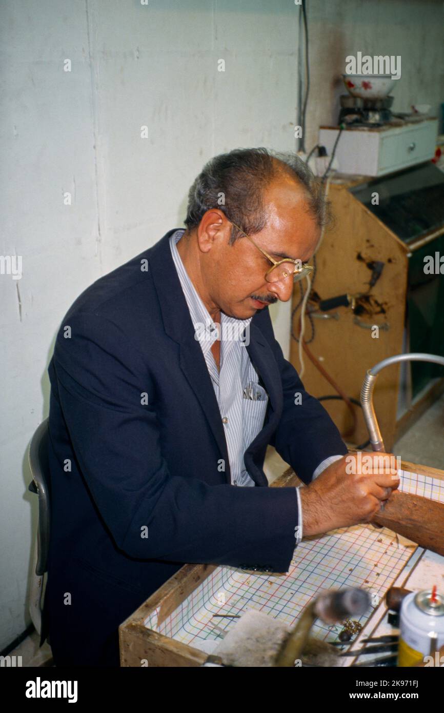 Kuwait City Kuwait Worker In Gold Market Using Soldering Pen Stock