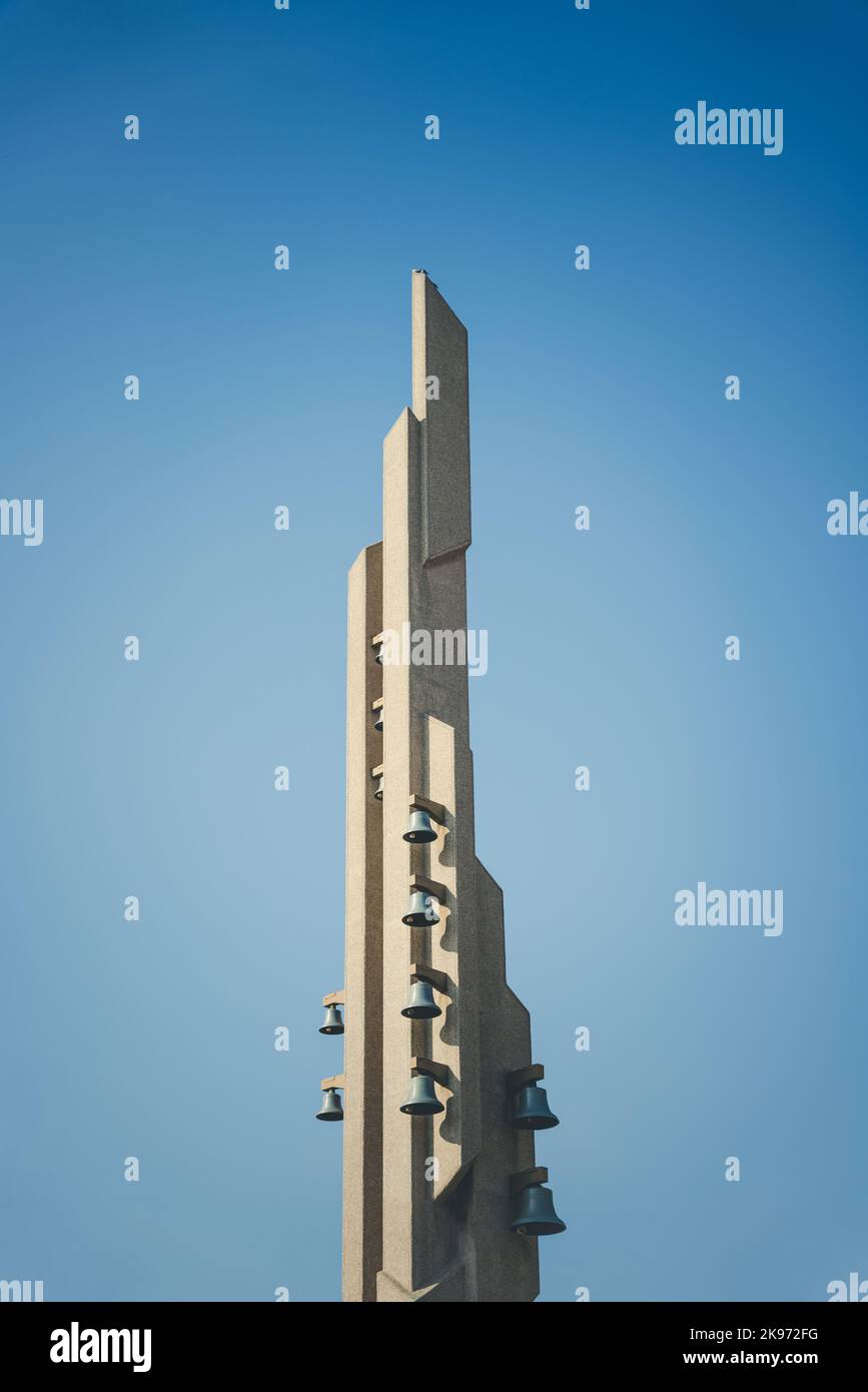 A vertical shot of the tall building with bells on the side with clear sky in the background Stock Photo