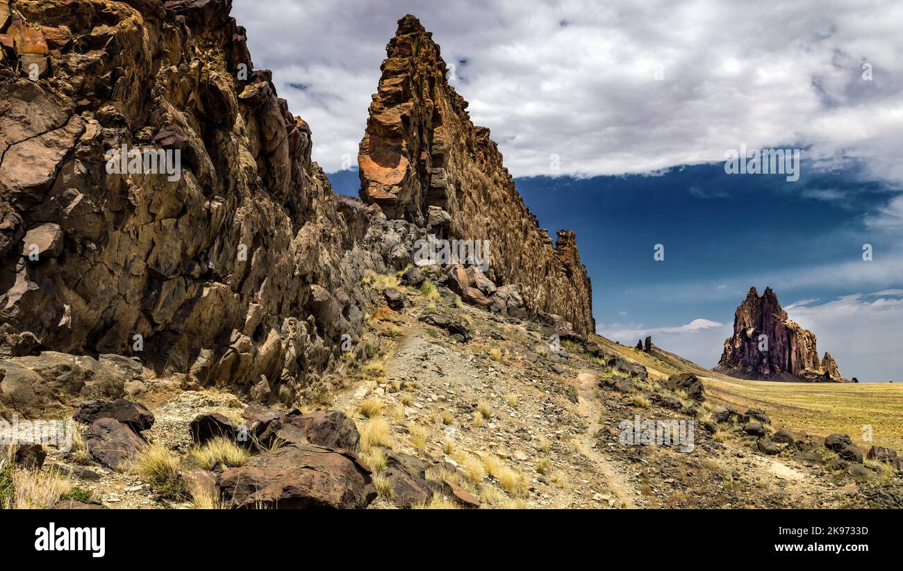 Basaltic Ridge Leading to Volcanic Plug, Shiprock, NM Shiprock is composed of fractured volcanic breccia and black dikes of igneous rock. Stock Photo