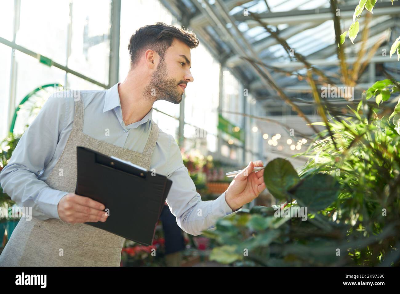 male florist taking notes on the clipboard. Stock Photo
