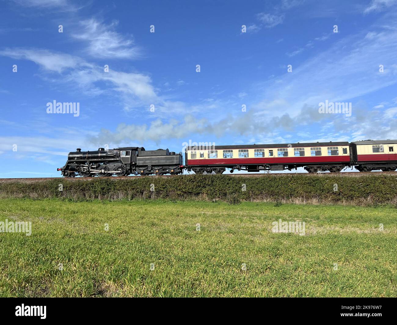 A steam train travelling through open countryside Stock Photo