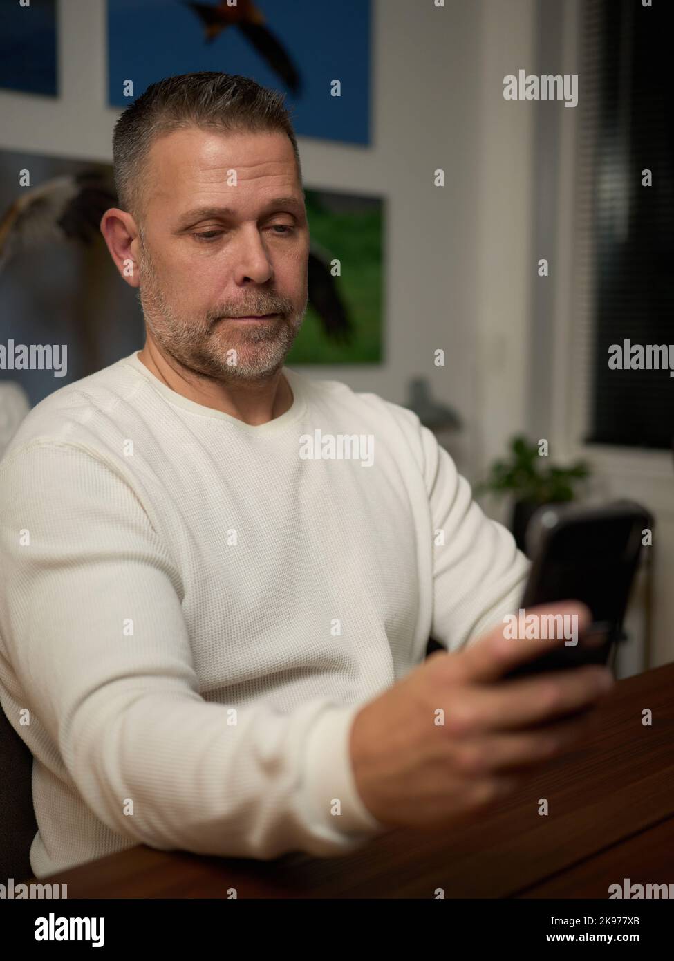 Middle aged man looking at his mobile phone Stock Photo
