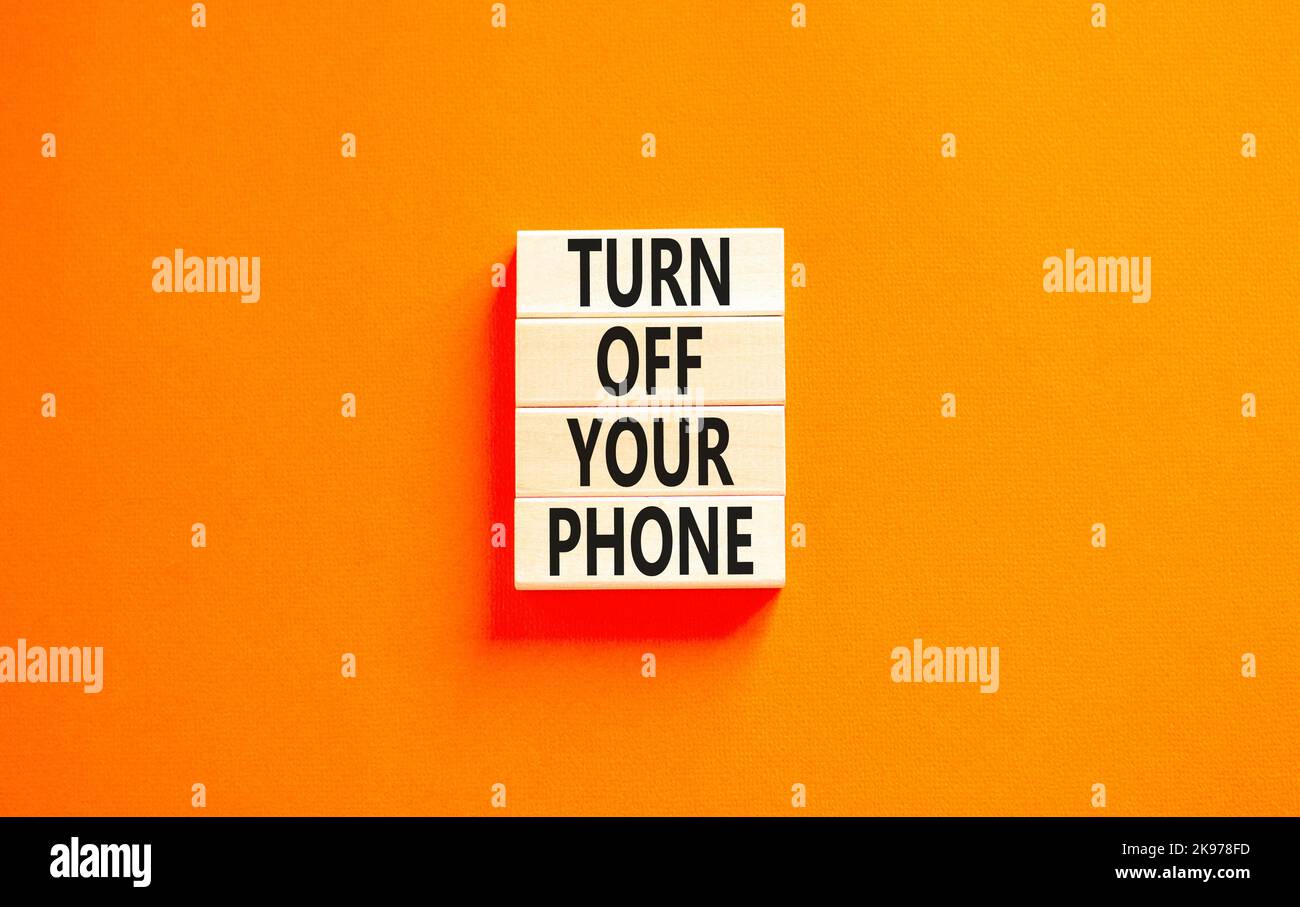 Turn off your phone symbol. Concept words Turn off your phone on wooden blocks. Beautiful orange table orange background. Business, psychological turn Stock Photo