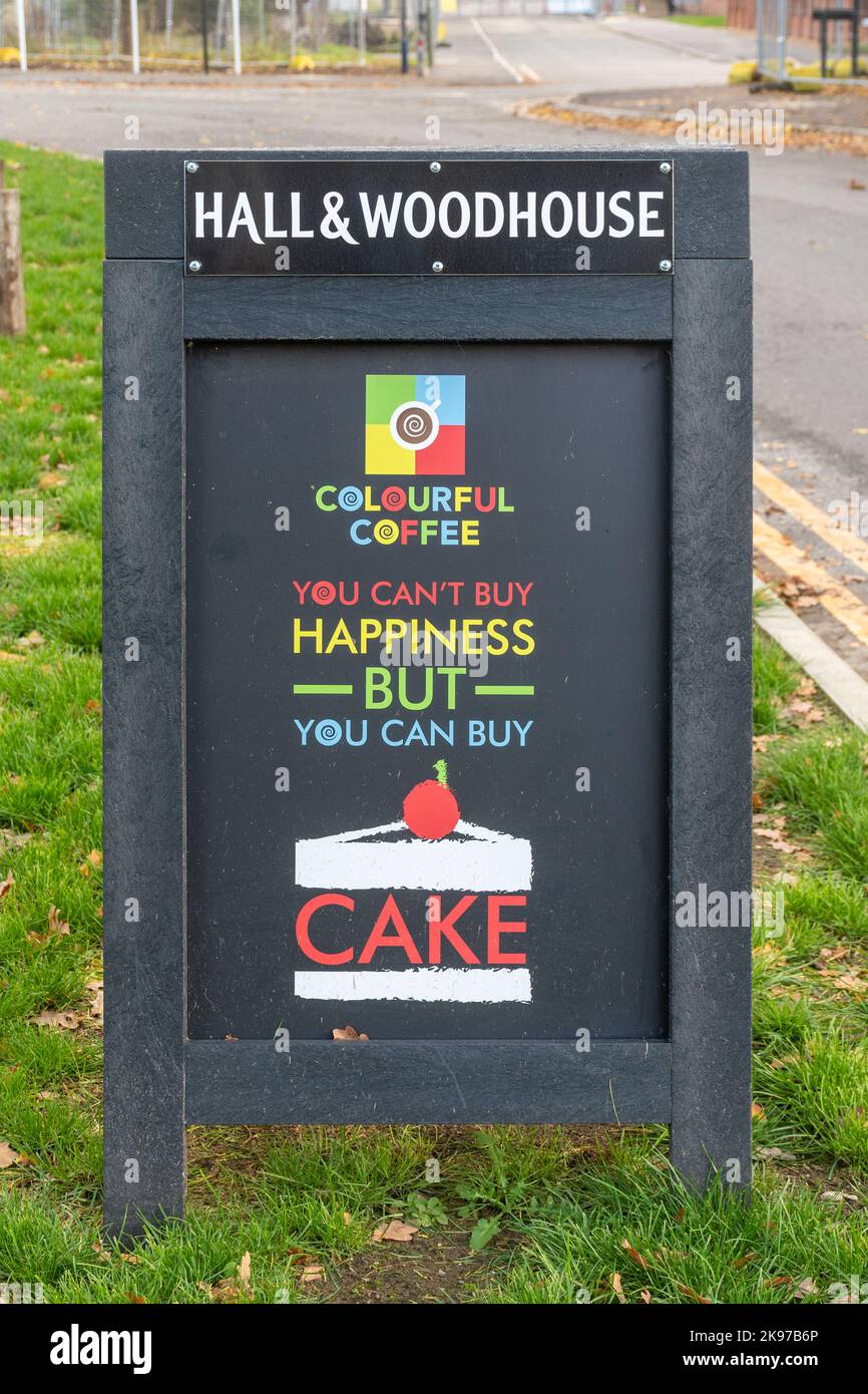 Amusing Hall & Woodhouse pub A-board sign advertising Colourful Coffee hot drinks and cake, you can't buy happiness but you can buy cake Stock Photo