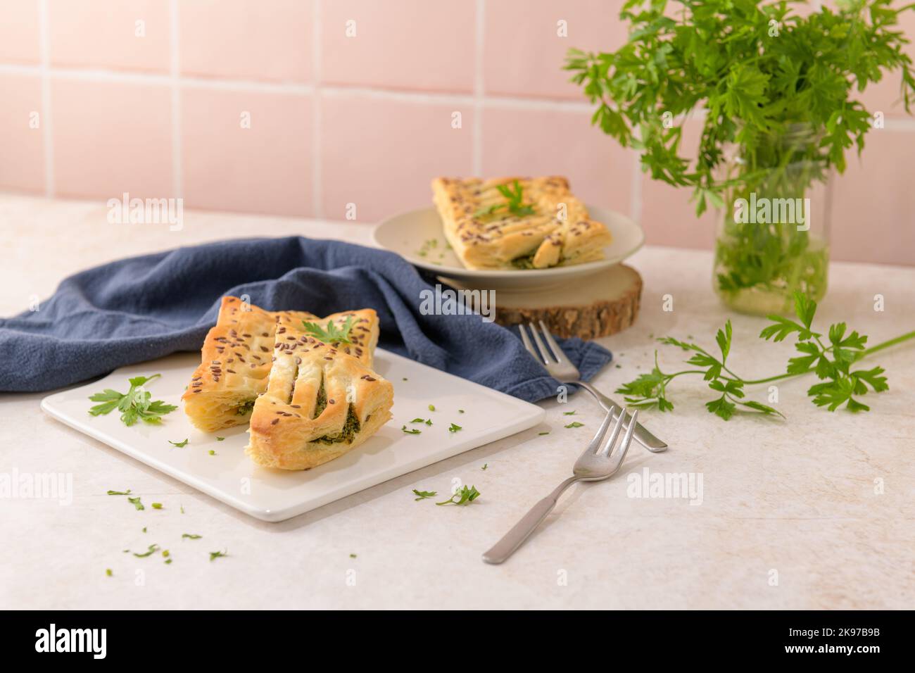 Spinach puff pastry with ricotta cheese and parsley leaves on white