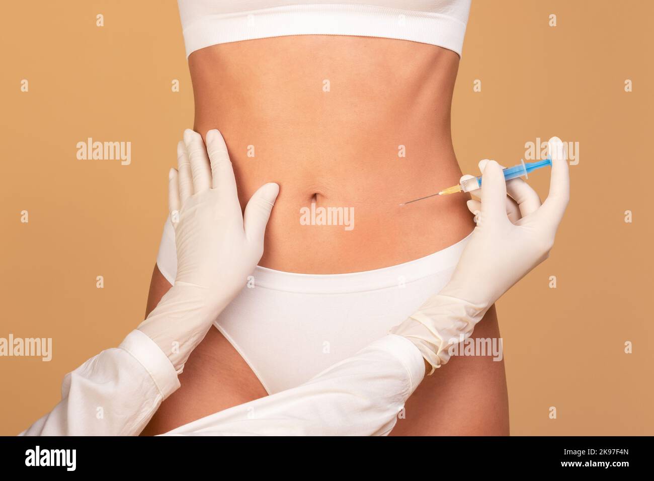 Beauty treatment. Closeup view of young fit woman getting injection in her belly area, having procedure in salon Stock Photo