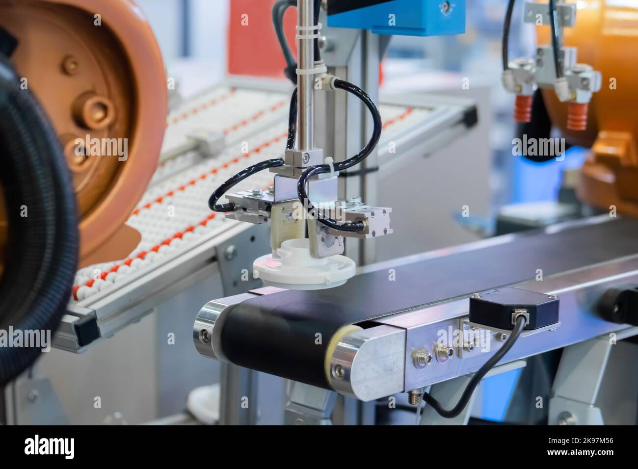 Pick and place robotic arm manipulator moving plastic detail on conveyor belt Stock Photo