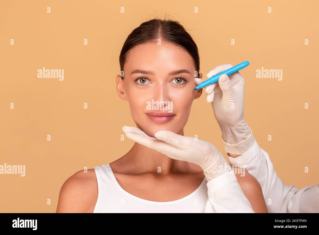 Lady before plastic surgery operation. Beautician touching and drawing