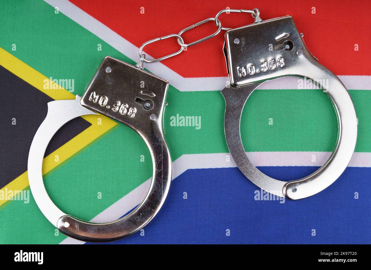 The concept of law and crime. There are handcuffs on the flag of the Republic of South Africa. Stock Photo