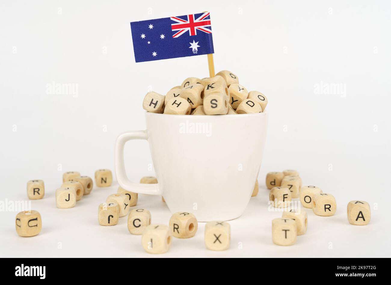 The flag of Australia sticks out of a cup with dice on which letters ...