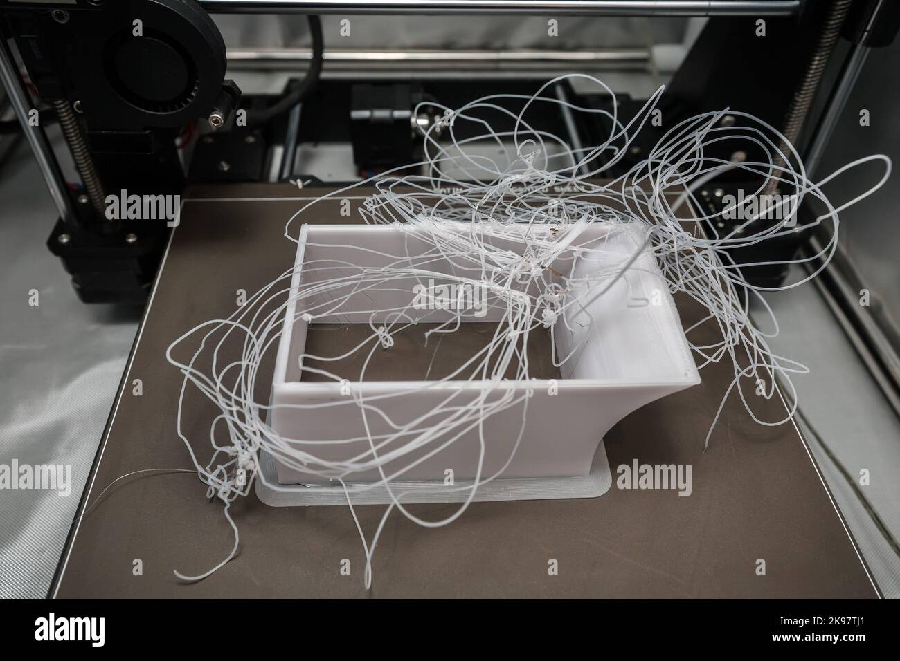 Failed 3d print of PETG filament on a satin metal sheet. Stock Photo