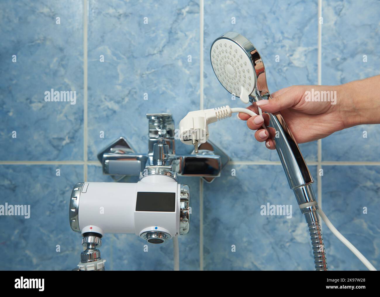 Shower with electric water heater in the bathroom. Stock Photo