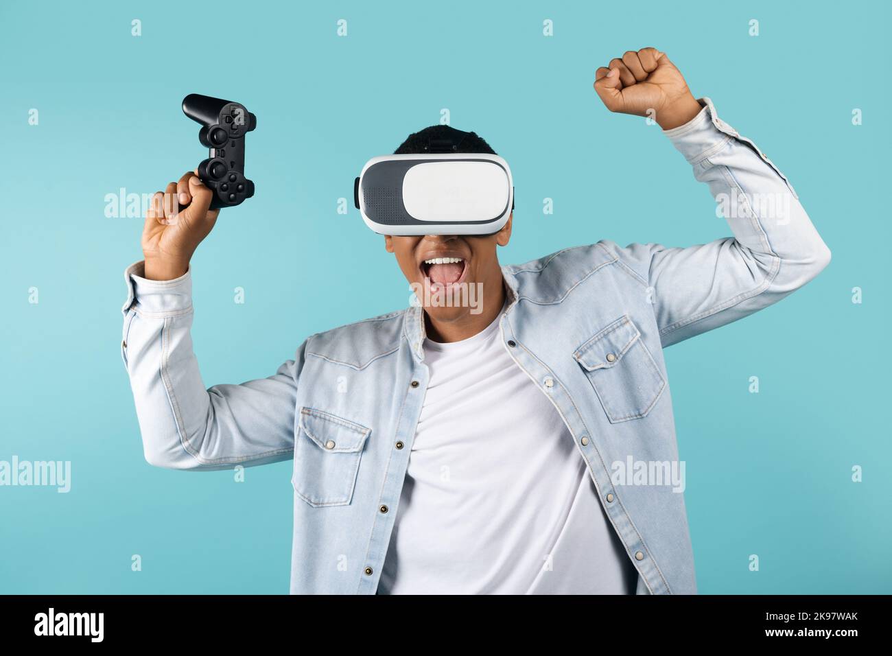 Cheerful excited millennial african american man with vr glasses and joystick rejoice to victory Stock Photo