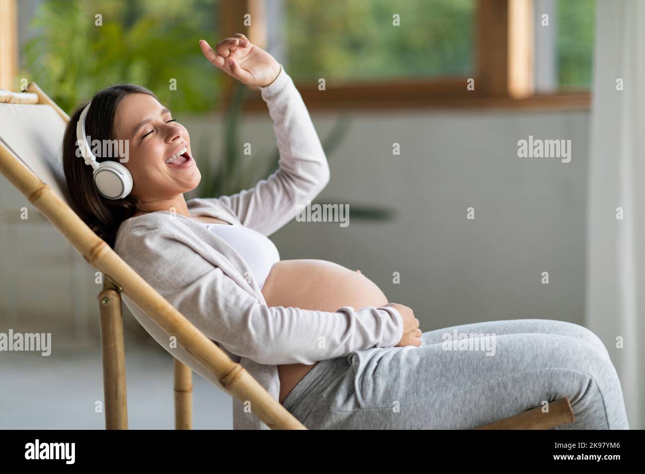 Smiling relaxed pregnant woman, future mom with tummy puts headphones on  belly for baby to listen to music. Pregnancy 24696873 Stock Photo at  Vecteezy