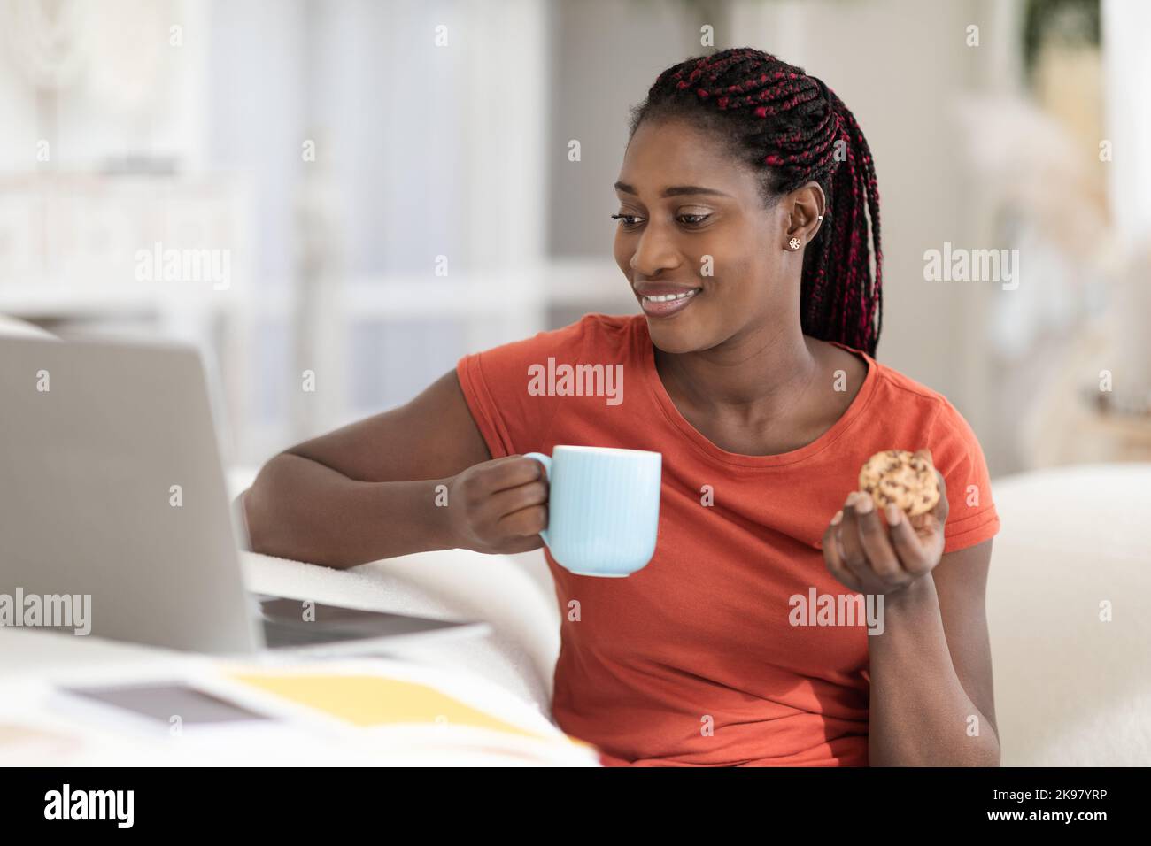 Cheerful Black Woman Relaxing At Home With Laptop And Snacks Stock ...