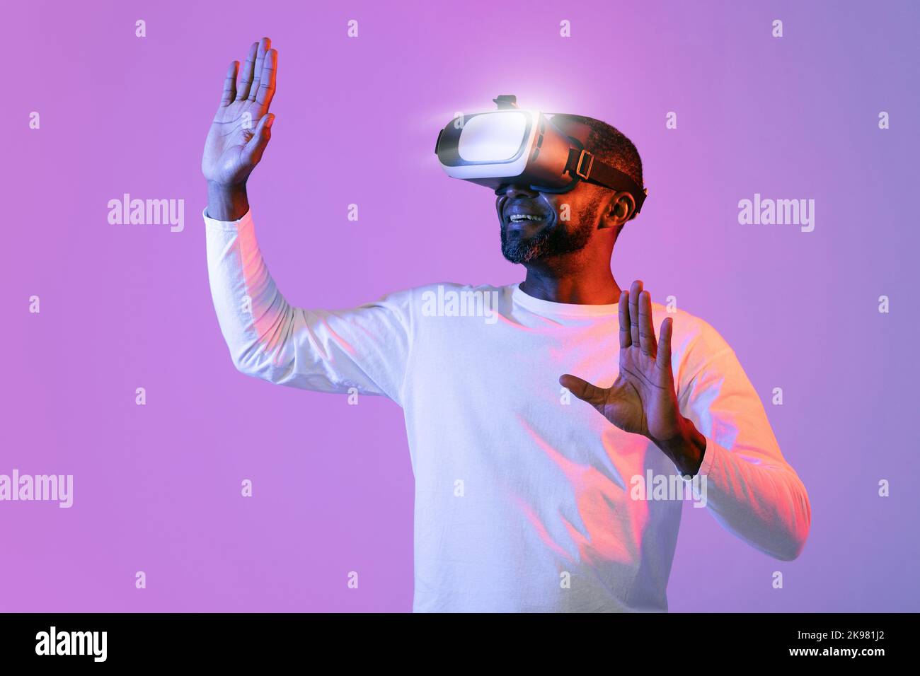 Man in vr glasses, trying to touch something with hands Stock Photo