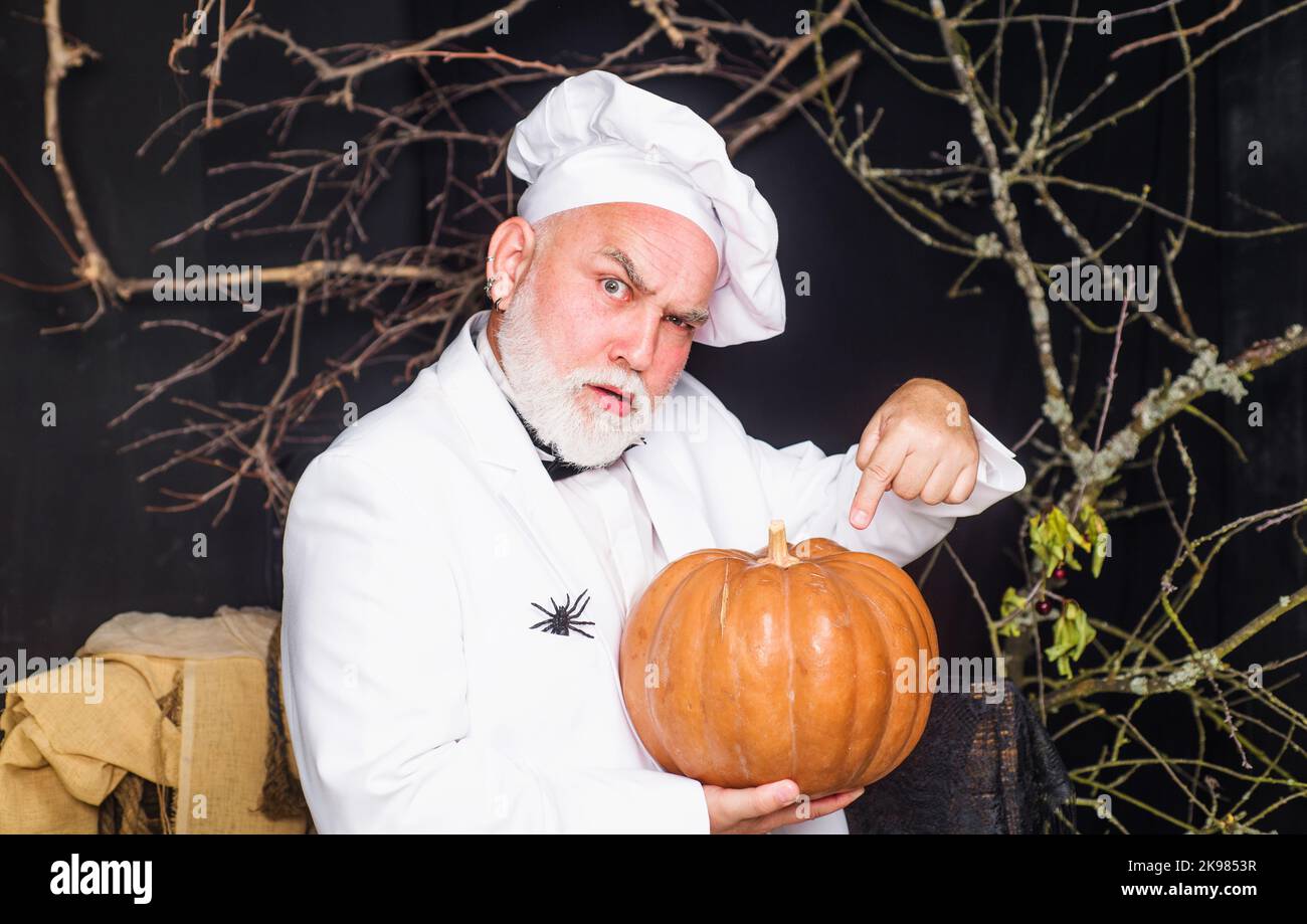 Chef in uniform with pumpkin. Happy halloween. Diet food. Healthy organic harvest vegetables. Stock Photo