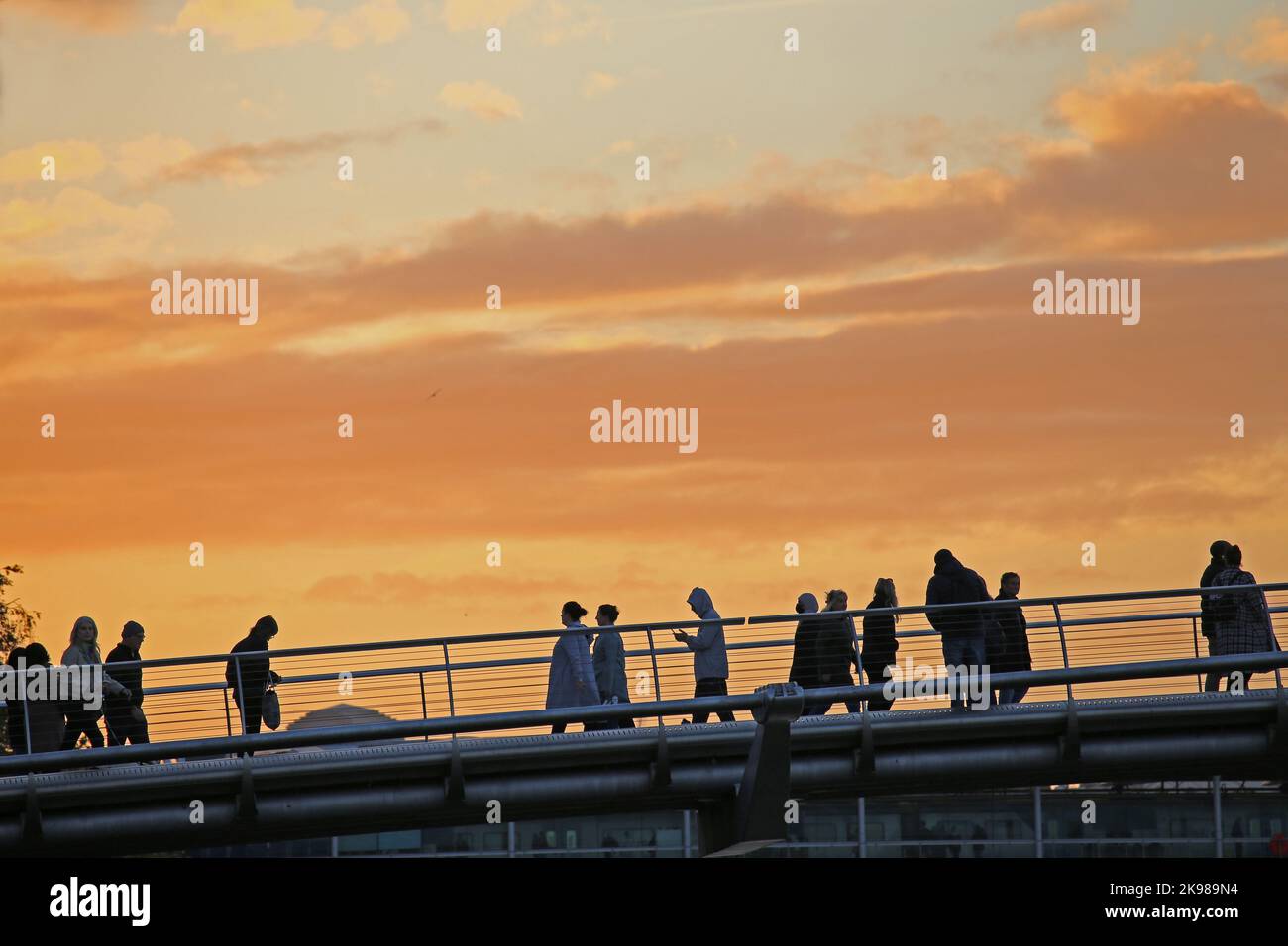 Millennium bridge or the wobbly bridge at sunset with tourists and walkers Stock Photo