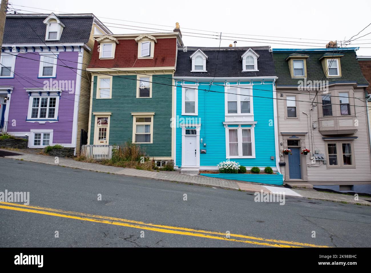 St. John's, Newfoundland, Canada-October 2022:Brightly colored wooden row houses with a blue sky in the background. The three story houses are colorful Stock Photo