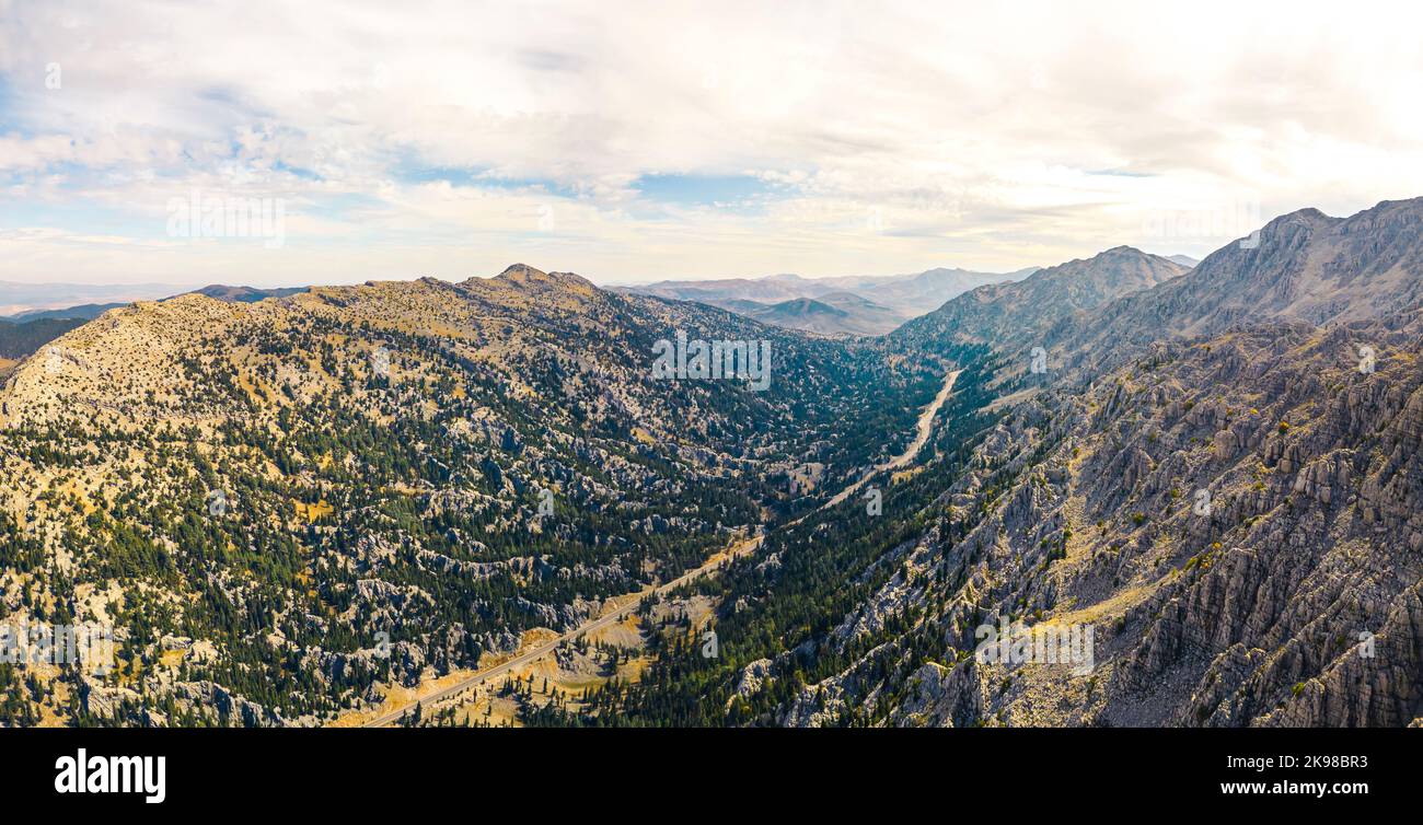 Drone wide panoramic view of Turkish mountain range named Taurus Mountains. Beautiful natural environment for hiking lovers. Cloudy sky. High quality photo Stock Photo